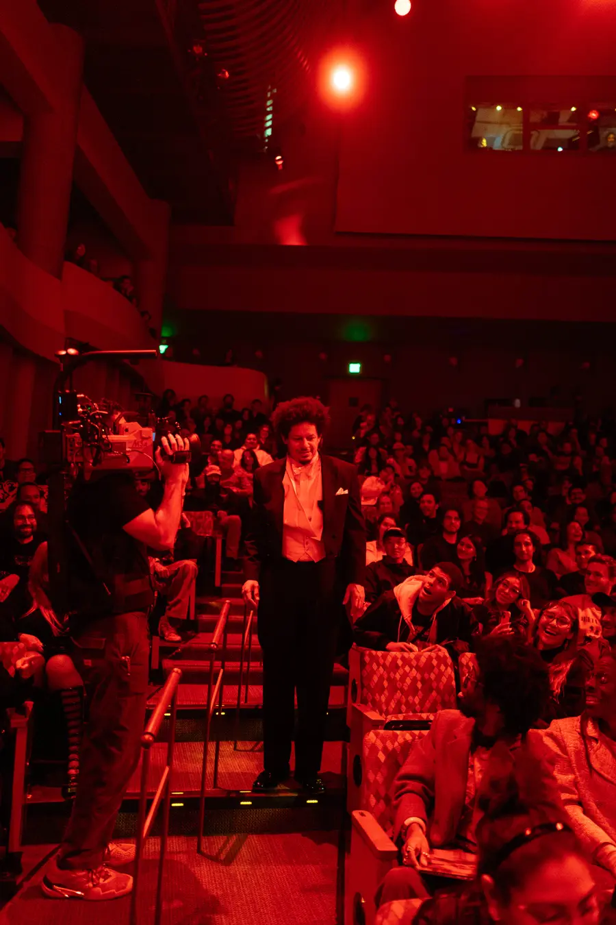 Eric Andre in the aisle as a camera operator films