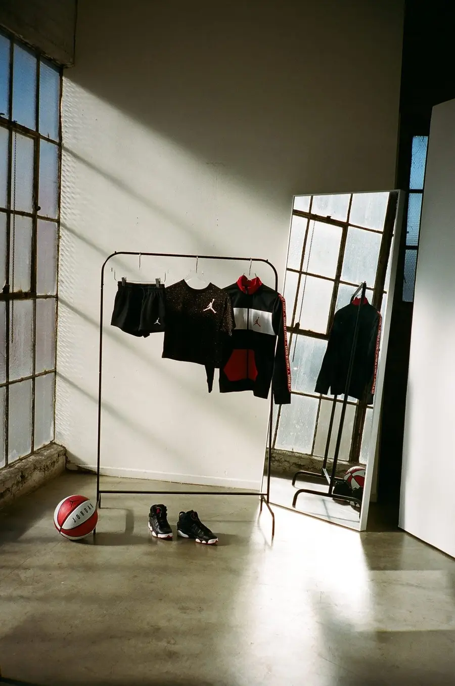 Jordan apparel on a studio rack with sneakers and a basketball