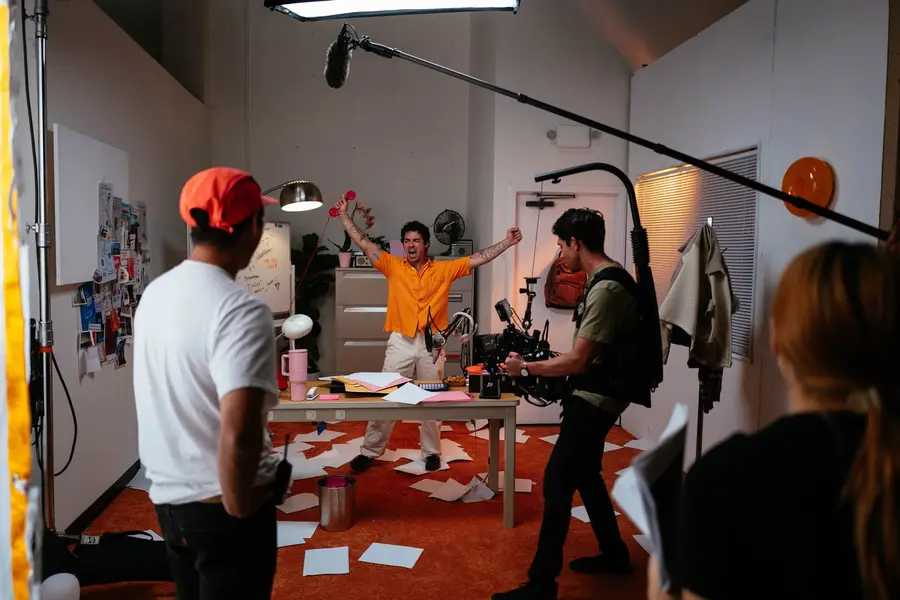 Joe Jonas with arms up on the Tinder Music Mode set, crew filming